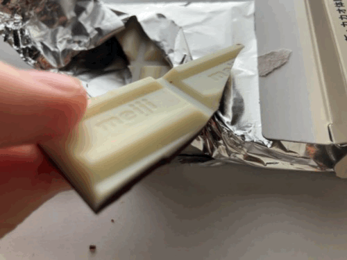 パキッと折ったチョコをつまんでる写真